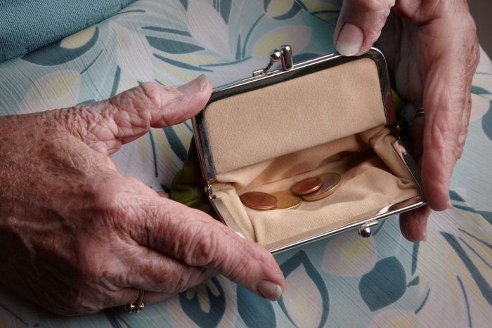 Elderly hands opening an empty purse