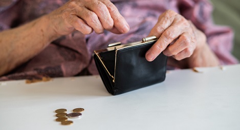 Elderly hands opening an empty purse